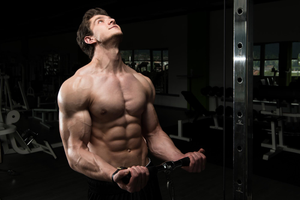 Powerful muscular man exercising biceps cable machine